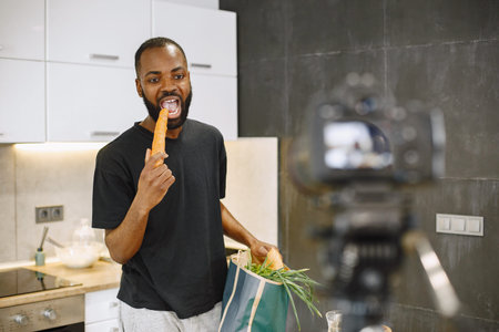 African male blogger recording vlog on digital camera