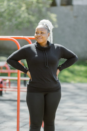 Afro-american plus size woman doing workout exercises session outdoor