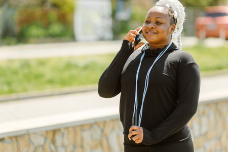 Afro-american plus size woman doing workout exercises session outdoor