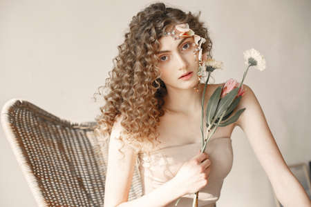 Portrait of a beautiful young woman with flowers. Tenderness and aroma.の写真素材