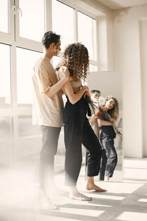 Emotional portrait of a boy and girl with flowers on their faceの写真素材