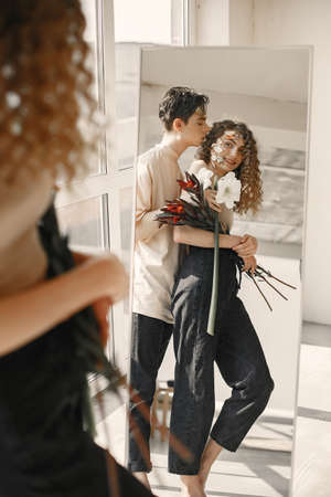 Emotional portrait of a boy and girl with flowers on their faceの写真素材