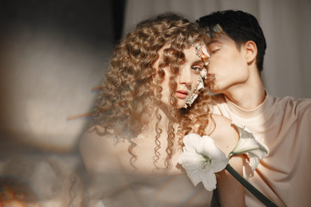 Emotional portrait of a boy and girl with flowers on their faceの写真素材