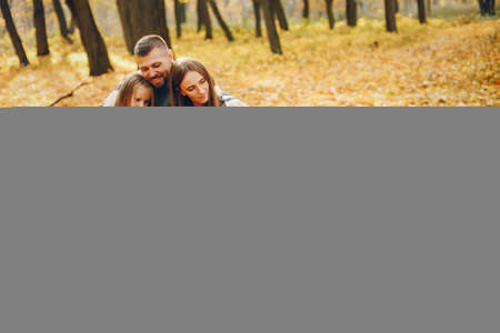 Family with cute kids in a autumn parkの写真素材
