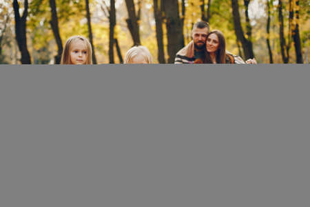 Family with cute kids in a autumn parkの写真素材