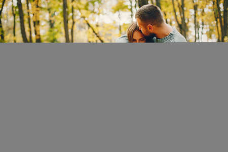 Beautiful couple spend time in a autumn parkの写真素材