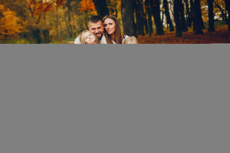 Family with cute kids in a autumn parkの写真素材