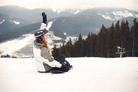Girl snowboarding in the mountains with the snowboardの写真素材