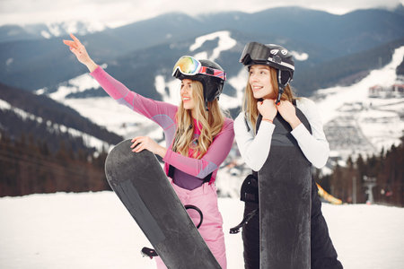 Girls snowboarding in the mountains with the snowboard