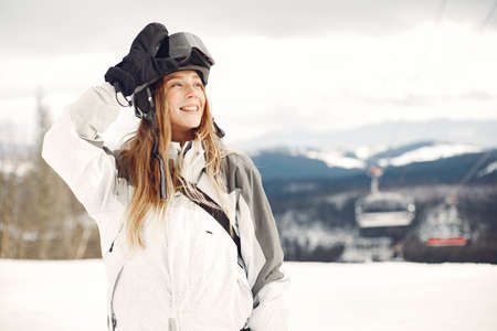 Girl snowboarding in the mountains with the snowboardの写真素材