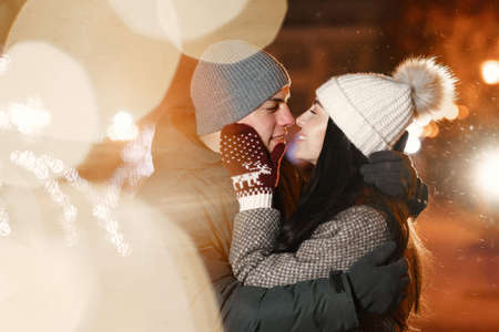 Young couple outdoor in night street at christmas timeの写真素材