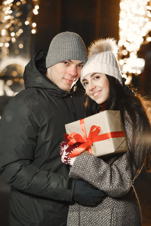 Young couple outdoor in night street at winter time