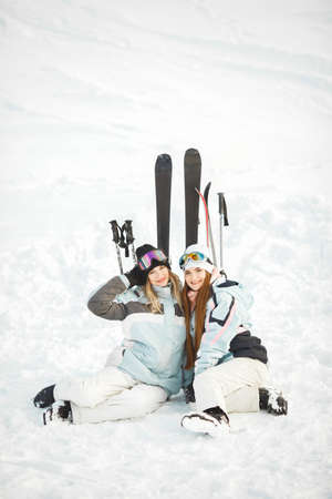 Girls posing against backdrop of mountains in ski gear.の写真素材