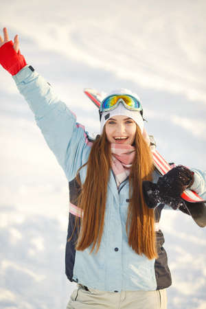 Skier on a mountain slope posing against a background of snow-capped mountainsの写真素材