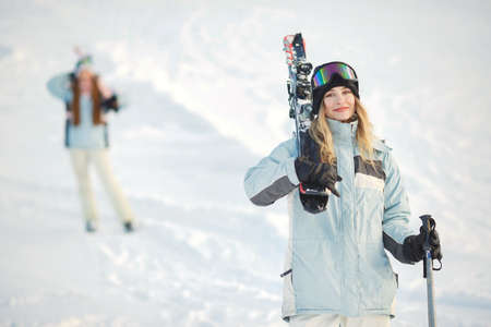 Skier on a mountain slope posing against a background of snow-capped mountainsの写真素材