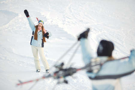 Skier on a mountain slope posing against a background of snow-capped mountainsの写真素材