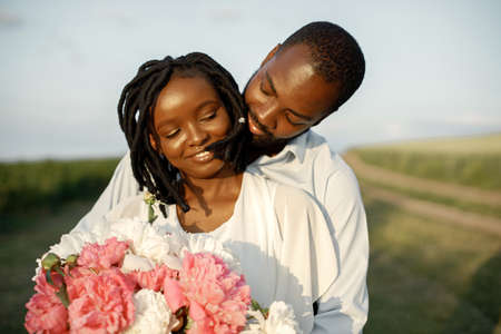 Happy romantic couple hugging in a summer fieldの写真素材