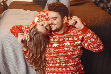 Cute couple sitting at home on a bedの写真素材