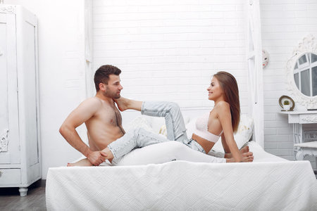 Couple lying on a bed in a room