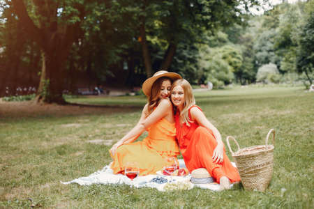 Elegant and stylish girls in a summer parkの写真素材