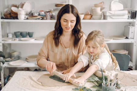 Portrait of mother and little girl shaping clay togetherの写真素材