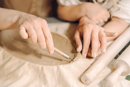 Portrait of mother and little girl shaping clay together