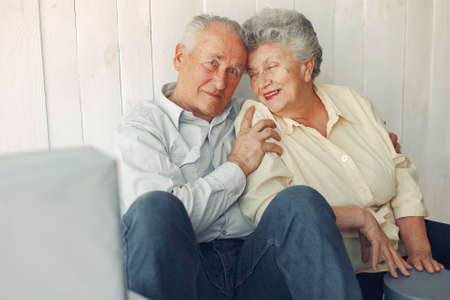 Elegant old couple sitting at home on a foorの写真素材