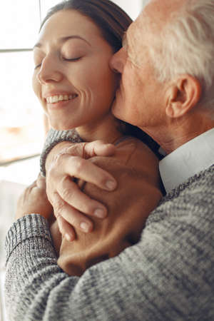 Elegant old man standing at home with his granddaughterの写真素材