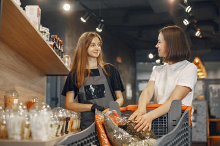 Female seller helps the buyer to choose the product.の写真素材