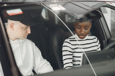 Young african american woman in car salon
