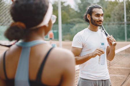 Two tennis players drinking a water on a tennis court before the matchの写真素材