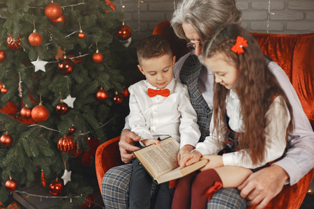 Smiling grandfather and grandchild with gift boxes sitting at homeの写真素材