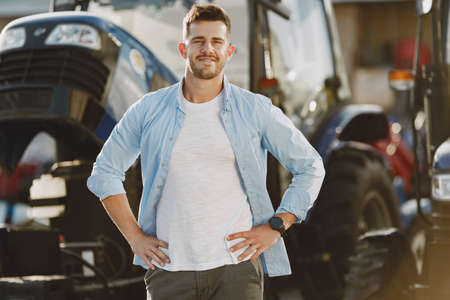 Male standing by the blue tractorの写真素材