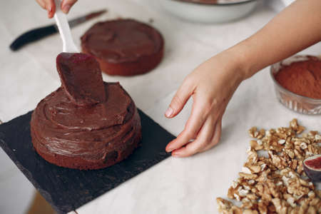 Chef spreads the cake with chocolate glaze.の写真素材