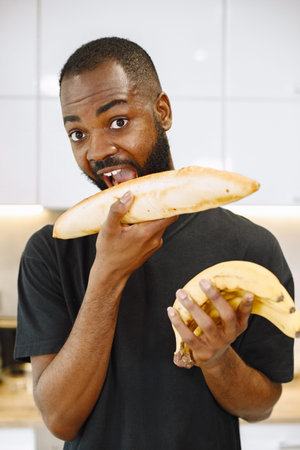 African-american man in a kitchen holding a bread