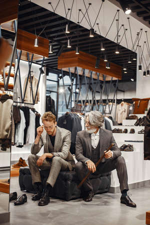 Senior man choosing a new suit in a storeの写真素材