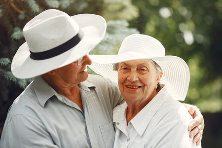 Beautiful old couple spend time in a summer gardenの写真素材