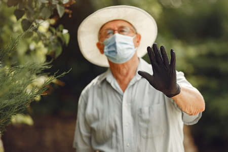 Old man in a medical mask at summer parkの写真素材