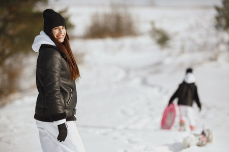 Mother and child in winter clothes play in winter park
