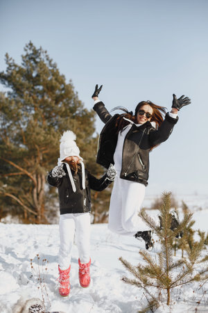 Mother and child in winter clothes play in winter park