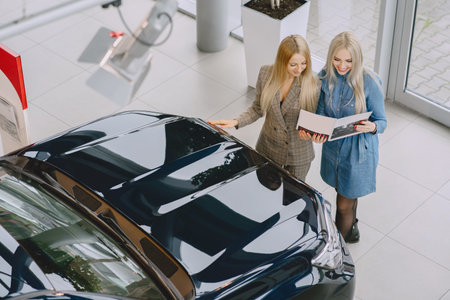 Stylish and elegant women in a car salon
