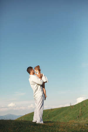 Father playing with ittle daughter in a mountainsの写真素材
