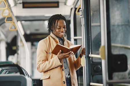 Young African businessman standing on a busの写真素材