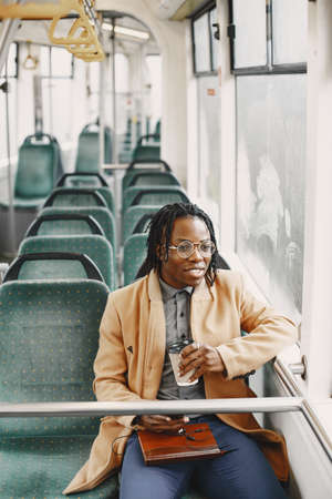 Young African businessman standing on a busの写真素材