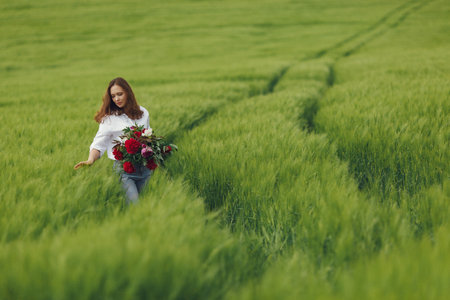 Woman in blue shirt in a summer fieldの写真素材