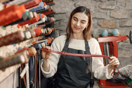 Woman tailor choosing colored spools of thread for sewing and embroideryの写真素材