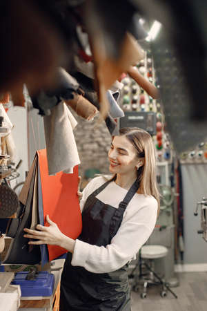 Woman tailor choosing a material leather sheet for her workの写真素材