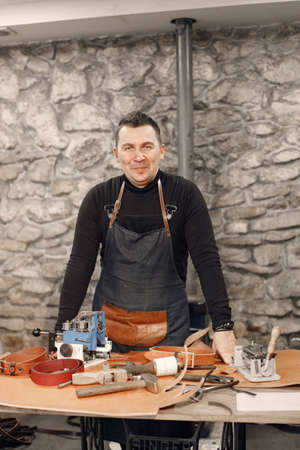 Portrait of a leather craftsman standing in his workspaceの写真素材