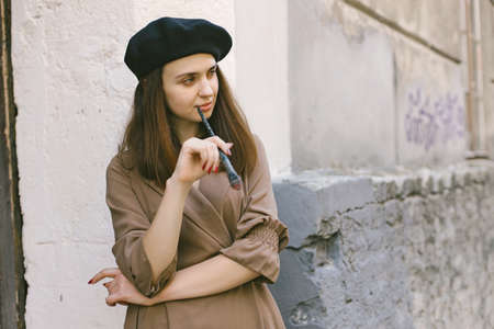 Girl in dress and black hat with painting brush in her handsの写真素材