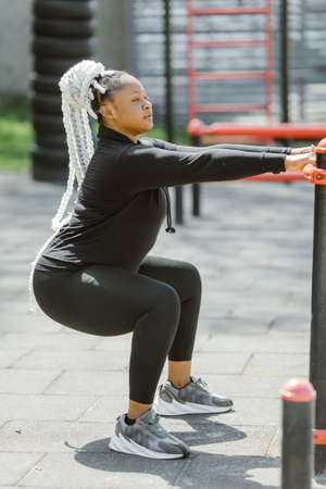 Afro-american plus size woman doing workout exercises session outdoorの写真素材